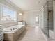Relaxing bathroom featuring soaking tub, shower and modern finishes at 4720 Gablestone Xing, Hoschton, GA 30548