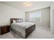Bedroom with neutral carpet, simple furnishing, natural light, and a dark wood bed frame at 4720 Gablestone Xing, Hoschton, GA 30548