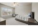 A well-lit bedroom boasts neutral walls, plush carpet, a window, and a ceiling fan for ultimate comfort at 4720 Gablestone Xing, Hoschton, GA 30548
