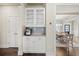 Elegant butler's pantry with glass cabinets, granite countertop, and beverage center at 4720 Gablestone Xing, Hoschton, GA 30548