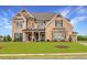 Charming two-story home with a stone and brick facade, manicured lawn, and a welcoming front porch at 4720 Gablestone Xing, Hoschton, GA 30548