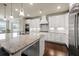 Bright kitchen features an island with granite countertops, stainless steel appliances, and white cabinetry at 4720 Gablestone Xing, Hoschton, GA 30548
