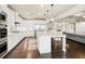 Spacious kitchen with white cabinetry, stainless steel appliances, large island, and hardwood floors at 4720 Gablestone Xing, Hoschton, GA 30548
