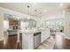 Open-concept kitchen with granite countertops, stainless steel appliances, and pendant lighting at 4720 Gablestone Xing, Hoschton, GA 30548