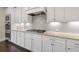 Beautiful kitchen showcases white cabinets, granite countertops, stainless steel appliances, and a tile backsplash at 4720 Gablestone Xing, Hoschton, GA 30548