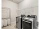 Laundry room featuring modern washer and dryer units, a shelf, and a cart, creating a clean and efficient space at 4720 Gablestone Xing, Hoschton, GA 30548