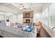 Inviting living room with a stone fireplace, coffered ceilings, and a large gray sofa with blue accents at 4720 Gablestone Xing, Hoschton, GA 30548