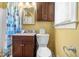 Well-lit bathroom featuring a dark vanity with granite countertop, toilet, and a shower with a patterned curtain at 4892 Duncan Dr, Powder Springs, GA 30127
