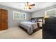 Bright bedroom with hardwood door, two windows, ceiling fan, and a queen-sized bed, creating a relaxing space at 4892 Duncan Dr, Powder Springs, GA 30127