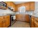 A view of the gas range, window and wooden cabinets in the kitchen at 4892 Duncan Dr, Powder Springs, GA 30127