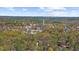 Scenic aerial view of a charming town nestled among lush trees and under a beautiful partly cloudy sky at 9860 Coleman Rd, Roswell, GA 30075