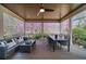 Relaxing covered porch with ceiling fan, outdoor seating, and view of flowering trees at 9860 Coleman Rd, Roswell, GA 30075