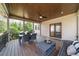Spacious covered porch with wood ceiling, outdoor furniture, and view of lush backyard at 9860 Coleman Rd, Roswell, GA 30075