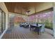 Covered porch features a ceiling fan, recessed lights, wood flooring, and outdoor furniture at 9860 Coleman Rd, Roswell, GA 30075