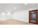 View of the basement highlighting light wood-look flooring and an ornate glass and wood wine storage room at 9860 Coleman Rd, Roswell, GA 30075