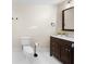 Well-lit bathroom featuring a toilet, vanity with dark cabinets, and a marble countertop at 9860 Coleman Rd, Roswell, GA 30075