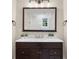Bathroom with vanity featuring dark cabinets, marble countertops and a large framed mirror at 9860 Coleman Rd, Roswell, GA 30075