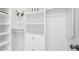 Bright, white, walk-in closet featuring built-in shelving and storage at 9860 Coleman Rd, Roswell, GA 30075