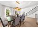 Bright dining area with hardwood floors, modern lighting fixture, and staircase view at 9860 Coleman Rd, Roswell, GA 30075