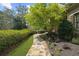 Charming stone path leads to the front entrance, framed by lush greenery and mature trees at 9860 Coleman Rd, Roswell, GA 30075