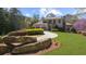 Beautifully landscaped front yard with mature trees and a long circular driveway leading to the home at 9860 Coleman Rd, Roswell, GA 30075