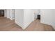 Hallway view showcasing beautiful light wood floors and white trim detail throughout the home at 9860 Coleman Rd, Roswell, GA 30075