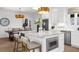 Close up of kitchen island with marble countertop, microwave, and seating for three at 9860 Coleman Rd, Roswell, GA 30075