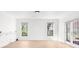 Bright living room with light wood floors, white walls, french doors, and many windows at 9860 Coleman Rd, Roswell, GA 30075
