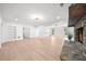 Spacious living room with fireplace, white walls, light wood floors, and recessed lighting at 9860 Coleman Rd, Roswell, GA 30075