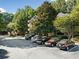 View of the building with ample parking spaces in a lush, green surrounding at 112 Bentley Pl, Tucker, GA 30084