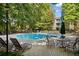 Relaxing community pool with lounge chairs and seating areas surrounded by lush greenery and mature trees at 112 Bentley Pl, Tucker, GA 30084