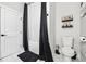 This bathroom has black trim, a toilet, and a bathtub shower with a black curtain rod and curtain at 503 Mcwilliams Se Rd, Atlanta, GA 30315