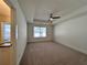 Spacious bedroom featuring neutral carpet, a tray ceiling with fan, and a bright window at 1910 Victoria Way # 120, Conyers, GA 30013