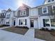 Gray townhome exterior with a manicured lawn and a bright sunny sky at 1910 Victoria Way # 120, Conyers, GA 30013