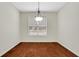 Bright dining room featuring a contemporary chandelier, large window and dark hardwood floors at 3485 Walnut Rdg, Atlanta, GA 30349