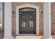 Elegant brick home featuring a stately front entry with a decorative iron door and sconces at 3485 Walnut Rdg, Atlanta, GA 30349