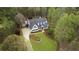 Aerial view featuring a home with a well manicured lawn, surrounded by mature trees at 12680 Old Surrey Pl, Roswell, GA 30075