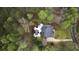 An aerial view of a private backyard oasis featuring a dark pool, lush landscaping, and nestled among mature trees at 12680 Old Surrey Pl, Roswell, GA 30075