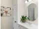 Elegant bathroom features a white vanity, sink, round mirror, and a decorative flower pot at 12680 Old Surrey Pl, Roswell, GA 30075