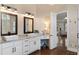 Bathroom featuring double sinks, a vanity, and an open doorway to the shower at 12680 Old Surrey Pl, Roswell, GA 30075