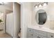 Stylish bathroom with white vanity, sink, vanity lights, and a shower with a white curtain at 12680 Old Surrey Pl, Roswell, GA 30075