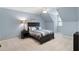 Comfortable bedroom featuring an accent wall, ceiling fan, and a large bed with stylish bedding at 12680 Old Surrey Pl, Roswell, GA 30075