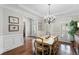 Elegant dining room featuring hardwood floors, plantation shutters, and a chandelier at 12680 Old Surrey Pl, Roswell, GA 30075