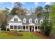 Inviting two-story home featuring a charming front porch and well-manicured landscaping at 12680 Old Surrey Pl, Roswell, GA 30075