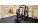 Spacious home gym with weight training equipment, rubber flooring, and natural light at 12680 Old Surrey Pl, Roswell, GA 30075