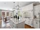 Bright kitchen with large island, white cabinetry, marble countertops, and adjacent breakfast nook at 12680 Old Surrey Pl, Roswell, GA 30075
