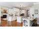 Gourmet kitchen with white cabinetry, marble countertops, stainless steel appliances, and adjacent living area at 12680 Old Surrey Pl, Roswell, GA 30075