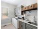Well-equipped laundry room boasts a sink, storage cabinets, marble countertop, and a modern washer and dryer at 12680 Old Surrey Pl, Roswell, GA 30075
