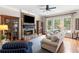 Comfortable living room featuring stone fireplace, built-in cabinets, and large windows overlooking the yard at 12680 Old Surrey Pl, Roswell, GA 30075