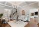 Bright living room features hardwood floors, a staircase, and views into the kitchen and front entry at 12680 Old Surrey Pl, Roswell, GA 30075